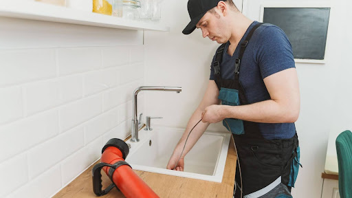 Plumber fixing kitchen sink drain